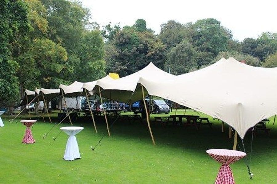 A white stretch tent pitched over a garden work area